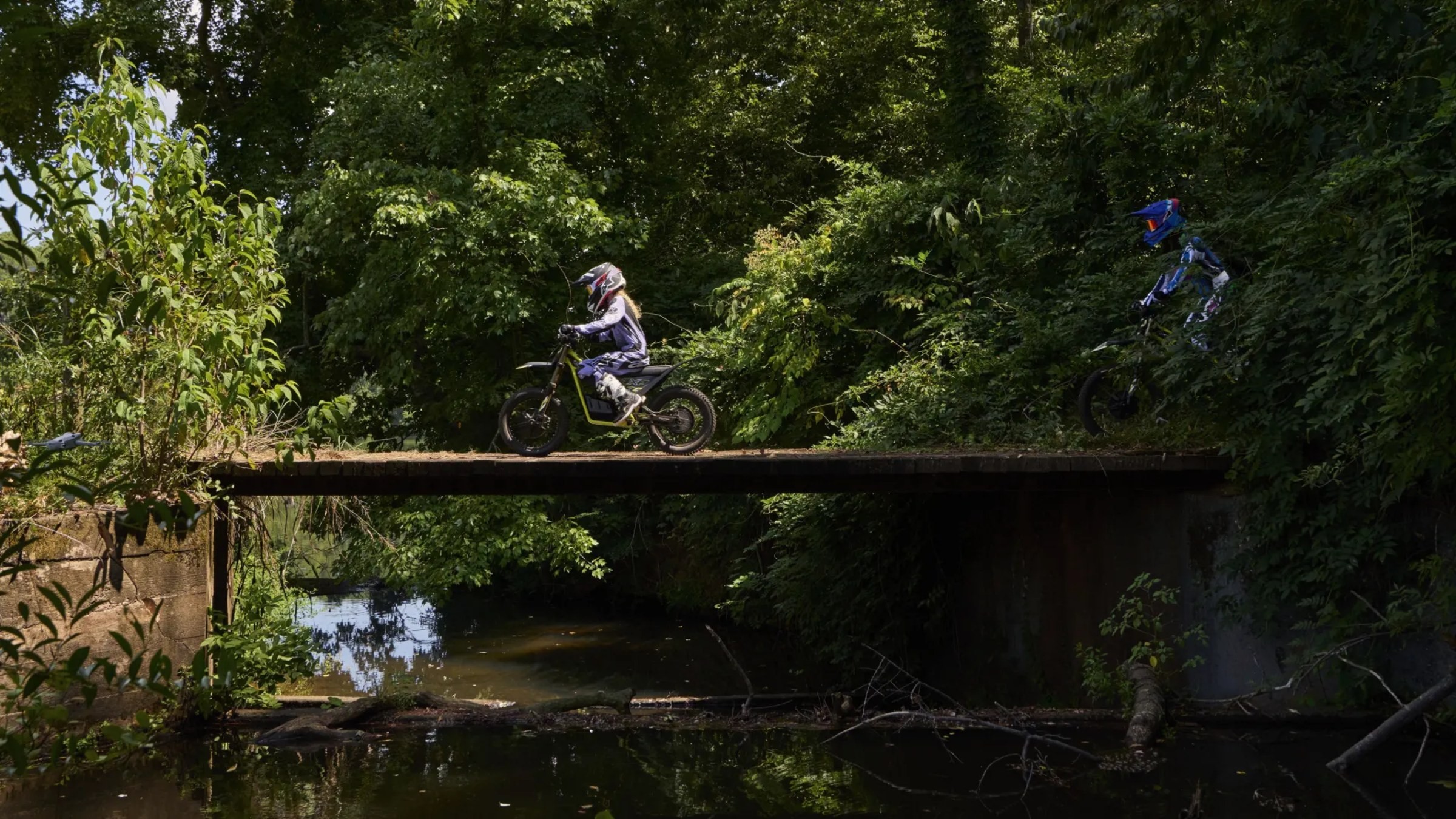 Triumph TXP-20 youth electric off-road bike near river bridge