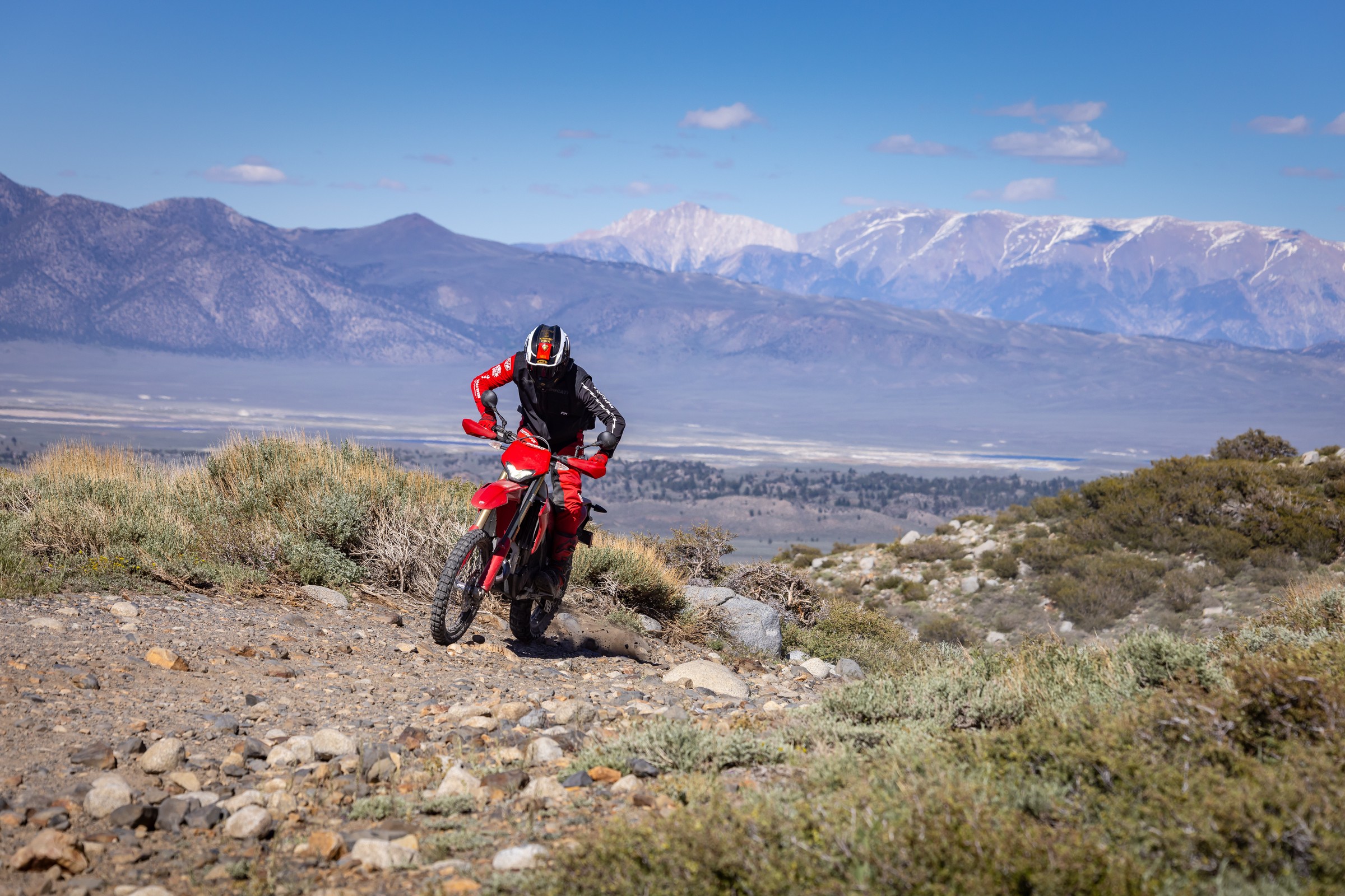 Desmo450 EDS climbing rocky mountain trail with valley backdrop