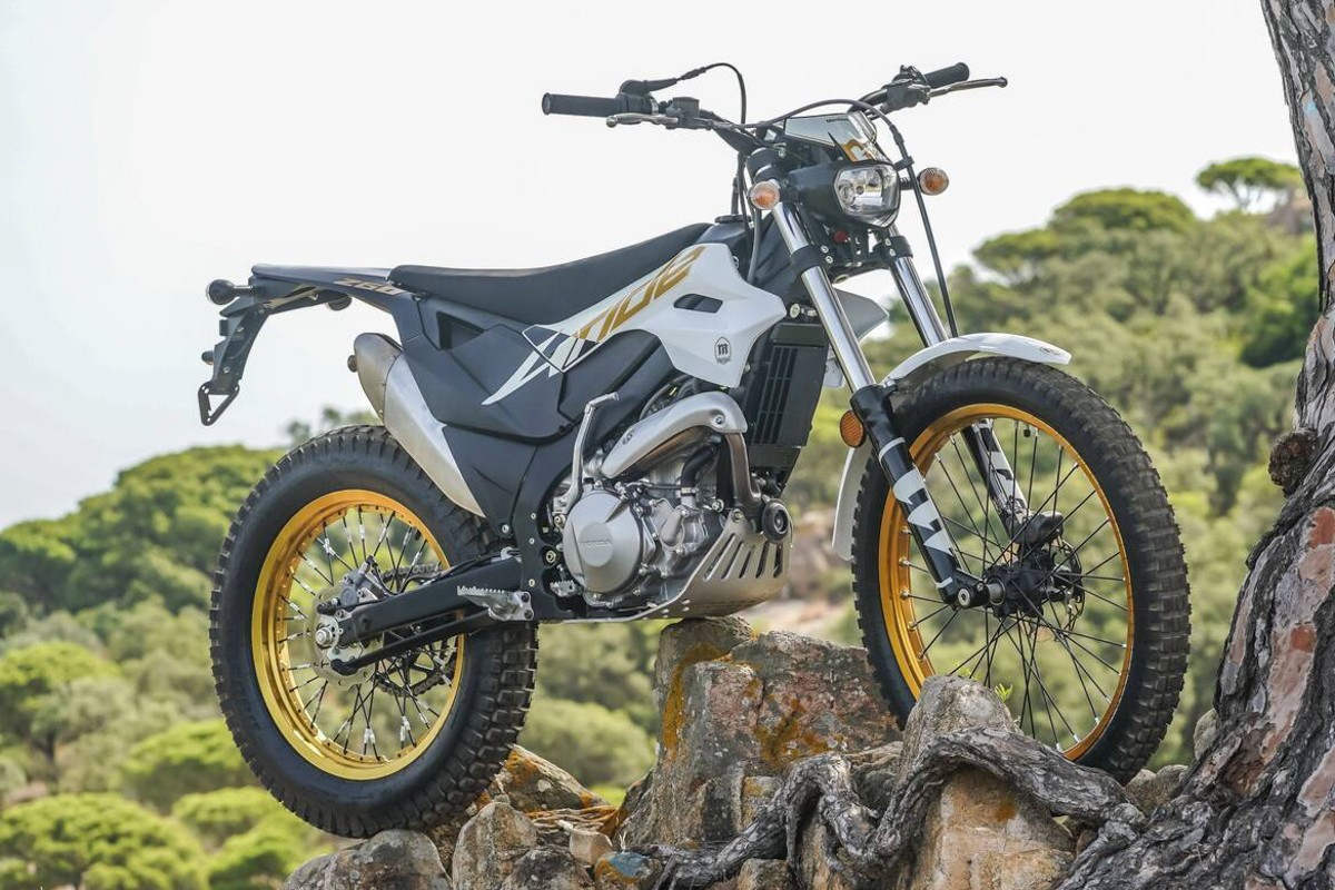 Montesa 4Ride parked on rocky outcrop — white/black trail-trial bike with gold rims