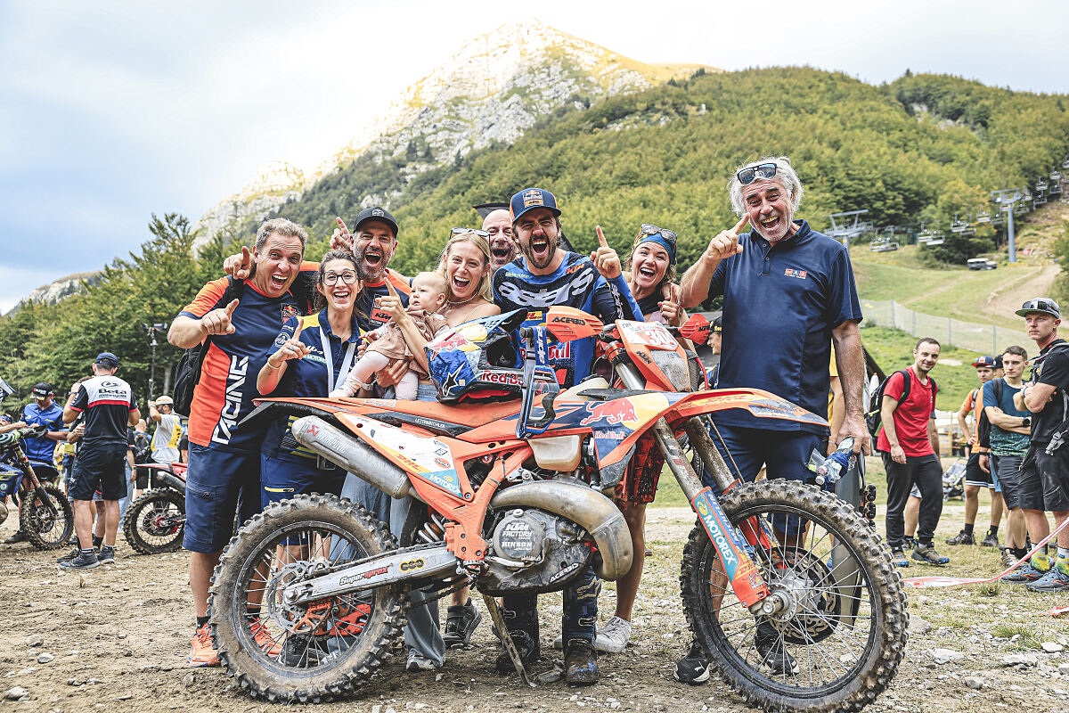 Manuel Lettenbichler and Red Bull KTM team celebrate Abestone Hard Enduro win with muddy KTM 300; Val di Luce mountain and chairlift behind