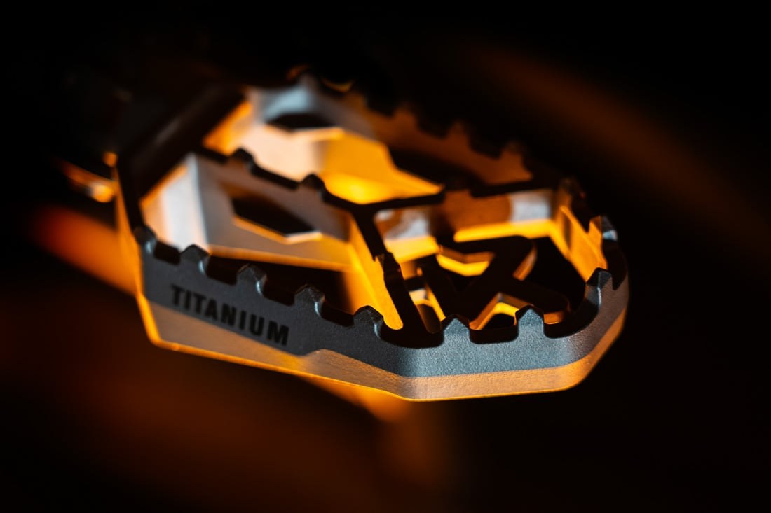 Single Akrapovič titanium footpeg dramatic studio lighting