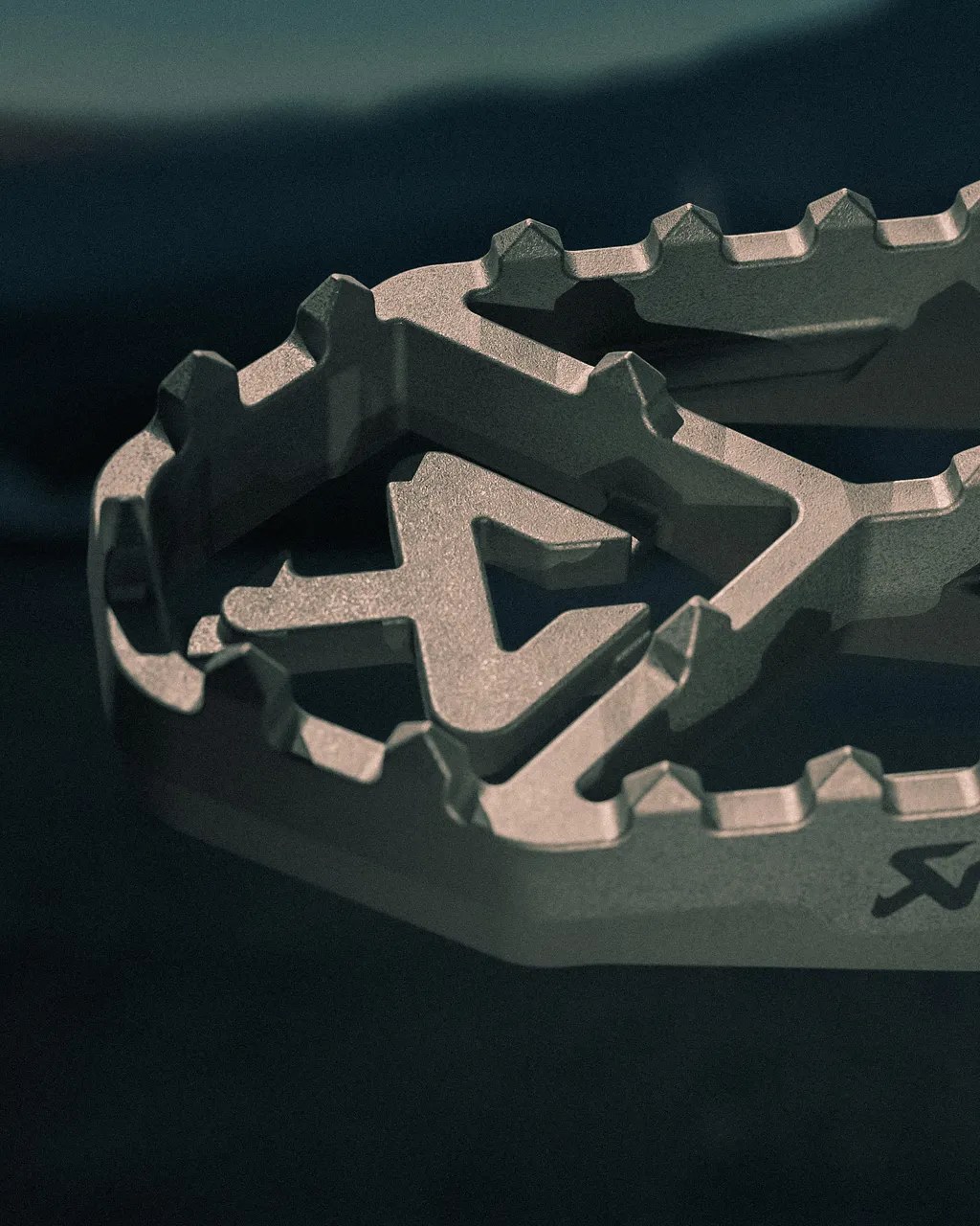 Close-up Akrapovič titanium footpeg teeth and cast A cutout