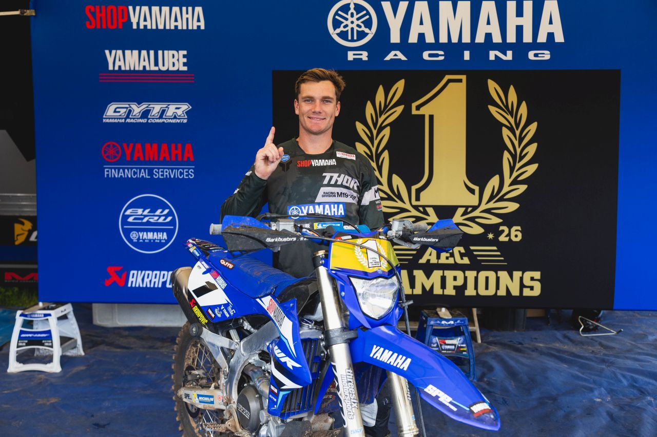 Wil Ruprecht (Shop Yamaha) with #1 plate WR450F and AEC Champions 2026 backdrop — Pro Enduro title