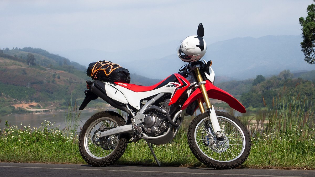 Honda CRF250L dual-sport with a waterproof soft bag strapped to the rear rack, Chiang Rai province, Thailand