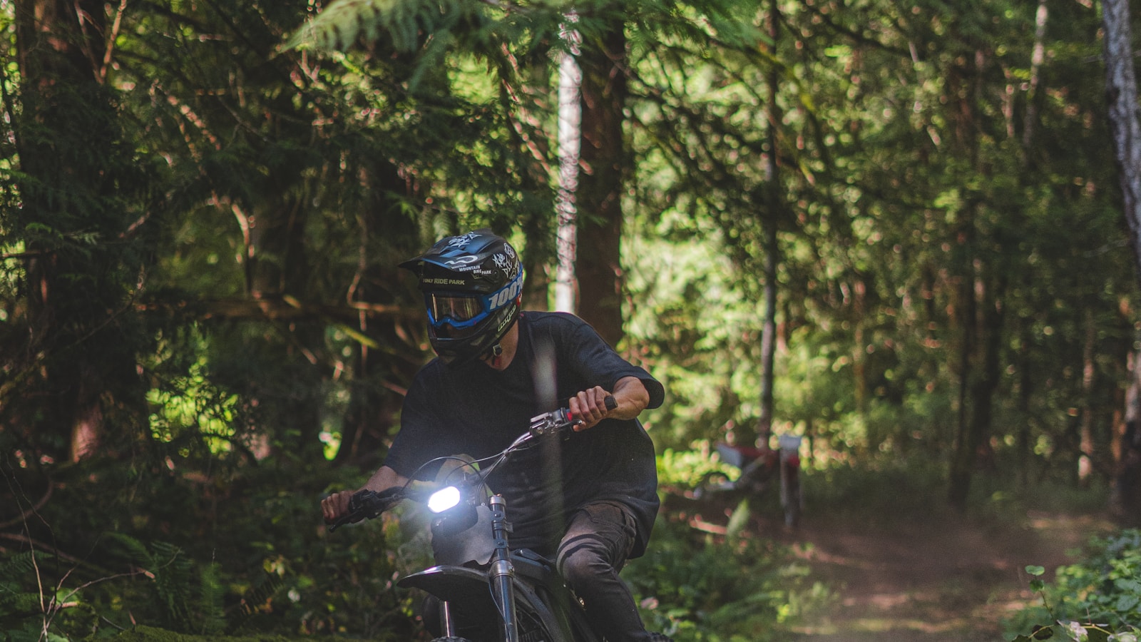 Off-road motorcycle rider on a wooded singletrack — class stand-in for John Penton GNCC woods racing at Sunday Creek