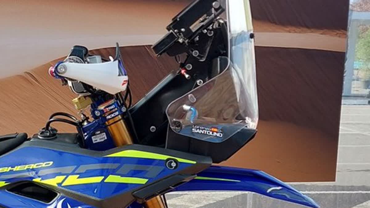 Close-up of white wraparound enduro handguards on a dual-sport/rally handlebar with levers and controls visible