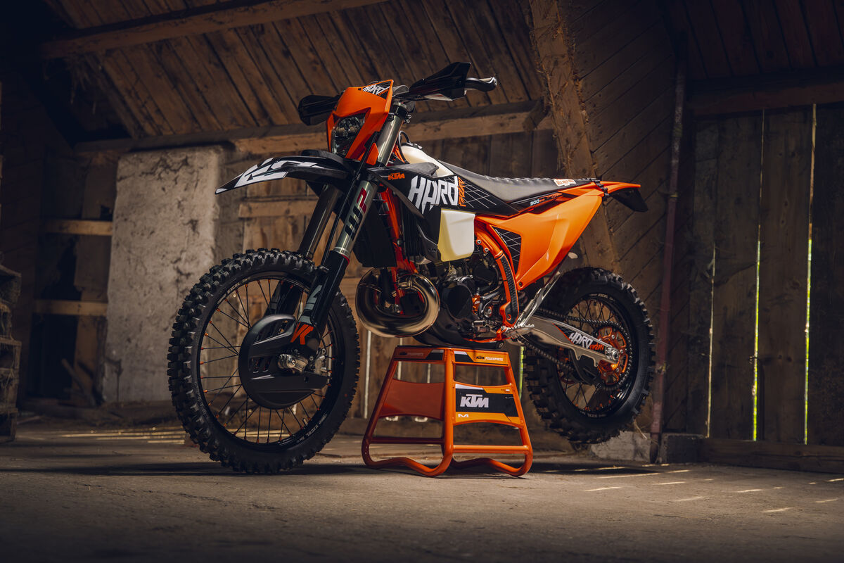 2027 KTM 300 EXC HARDENDURO on an orange KTM stand inside a dim wooden barn