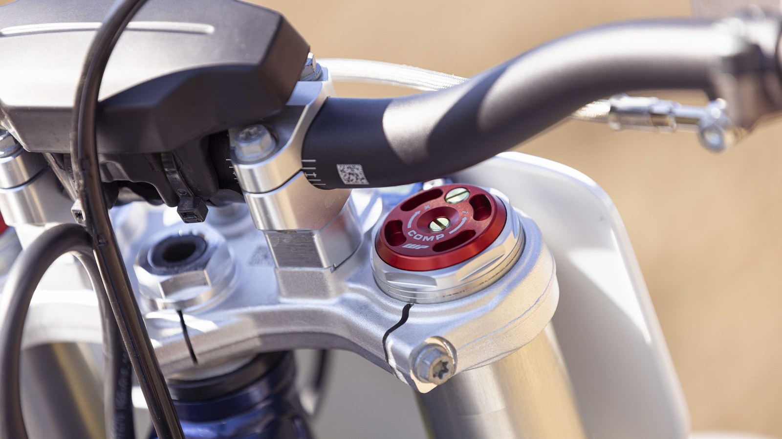 Close-up of a WP XACT PRO fork top cap with its red COMP compression clicker beside the handlebar clamp of a minicross bike